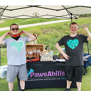 PawsAbilities employees pose in front of their pop up tent.