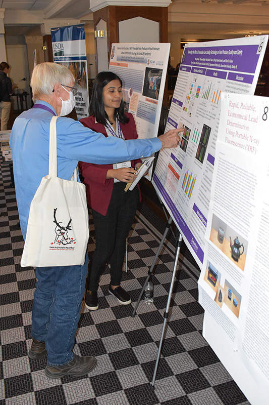 Student presenting reseach poster at Urban Food Systems Symposium. 