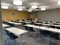 Room with tables set up in rows from the back/audience perspective. 