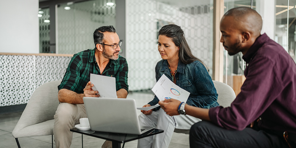 Financial planner talking with clients in office.