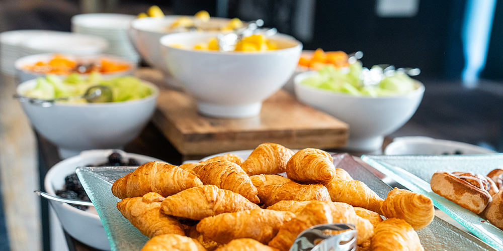 Bowls of fruit and pastries on a table.