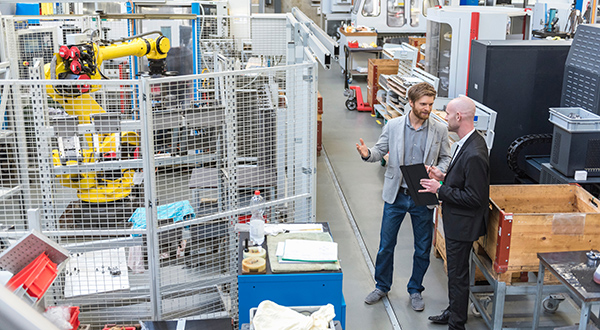 Floorman and manager discussing operations on the floor of a production facility.