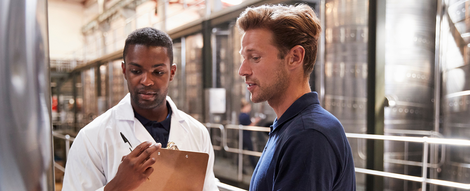 Scientist talking to bio-engineer about the animal health product being developed. 