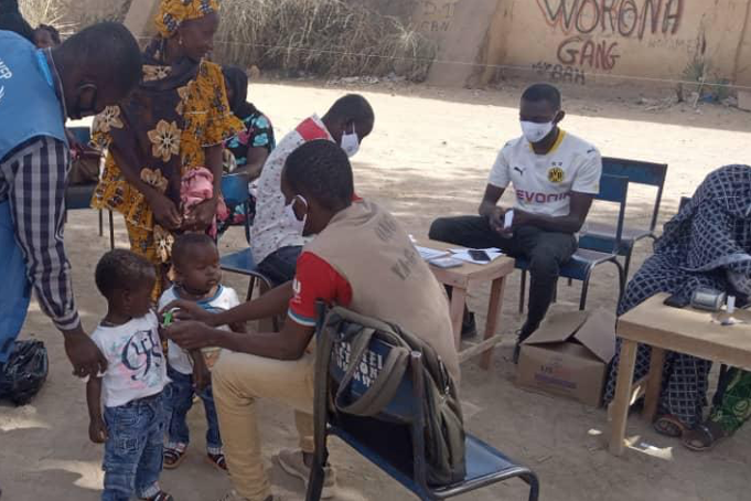 An agent from a local NGO screening children during food distribution in Niono Circle, Segou region.