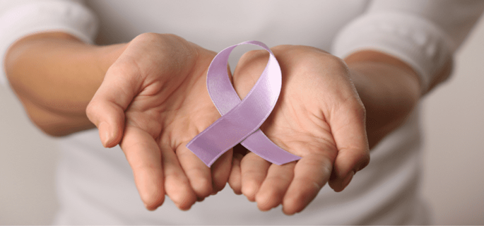 Hands holding purple ribbon in shape of cancer awareness.