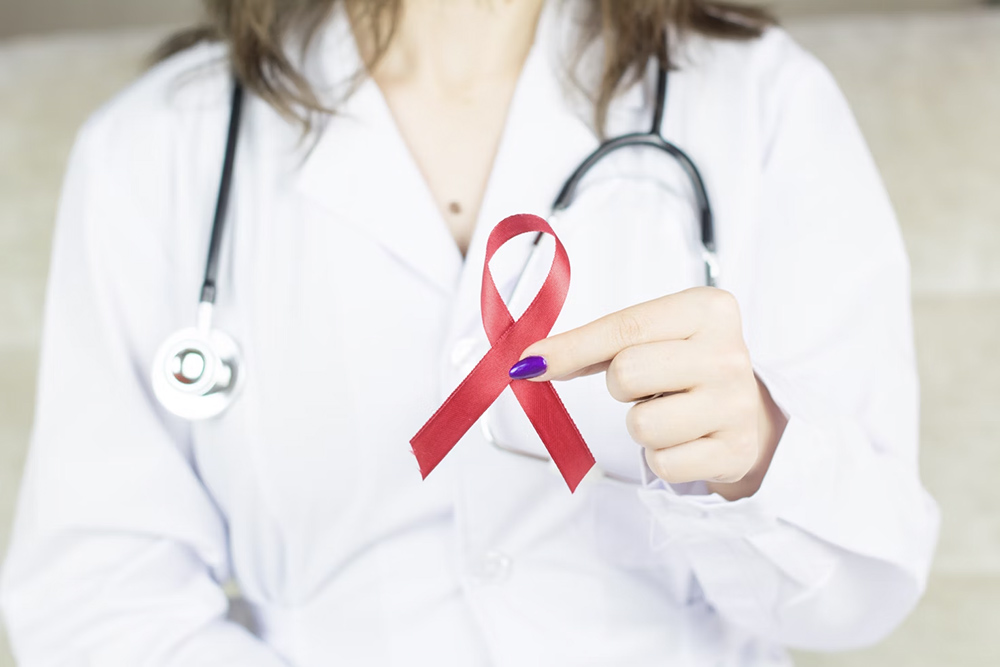 Hands holding a ribbon in shape of cancer awareness.